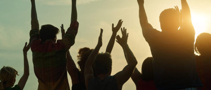 Back view silhouette of people at open-air live concert.